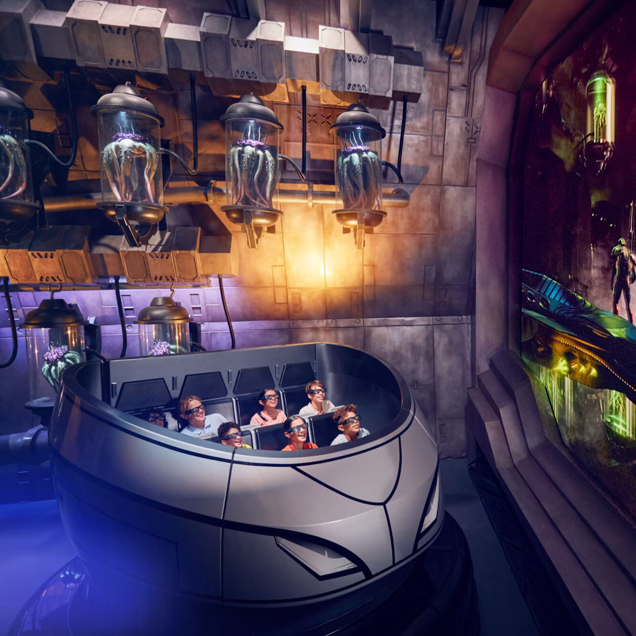 People seated in a themed amusement ride vehicle surrounded by sci-fi decor with glowing effects and screens.