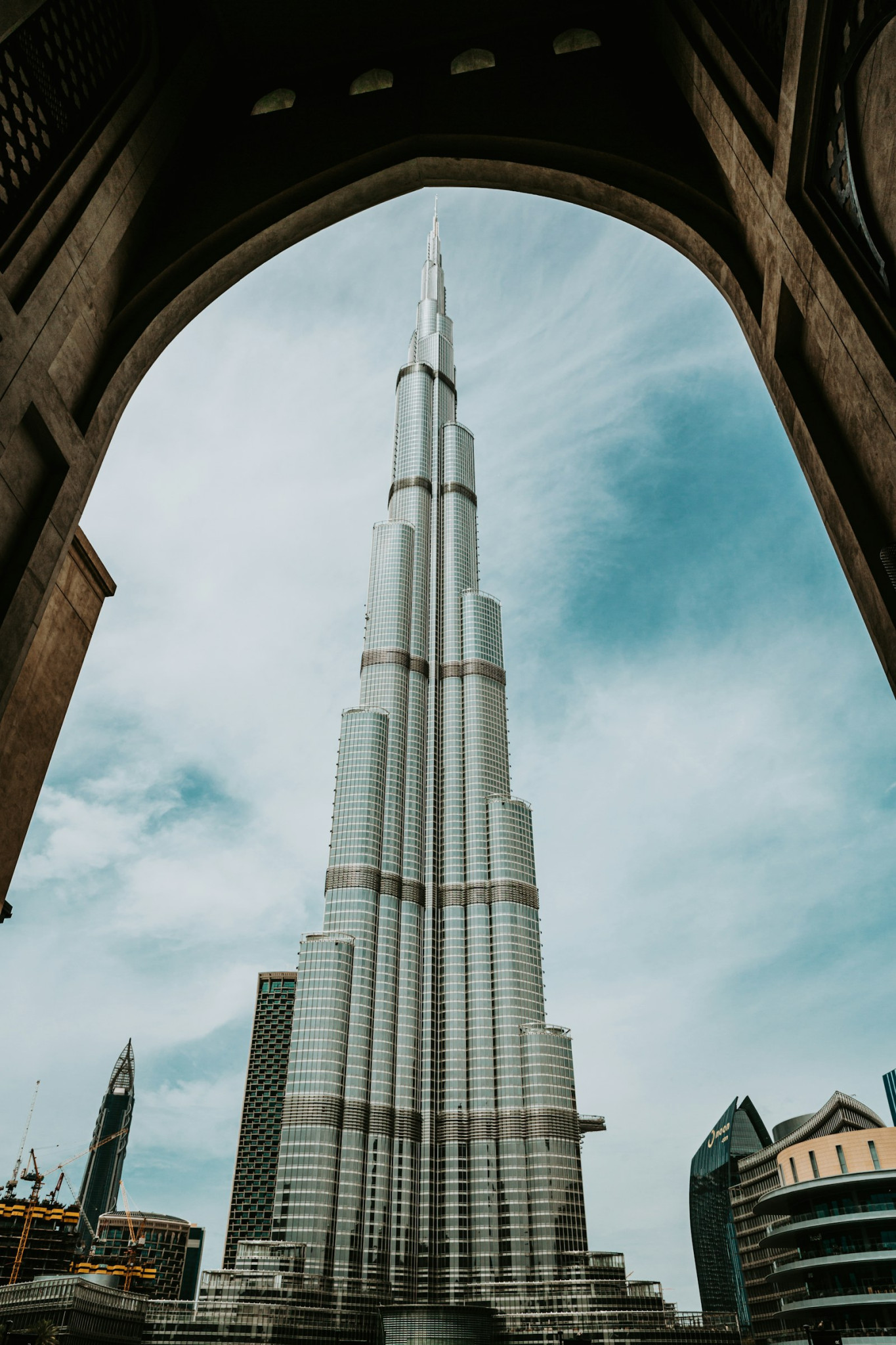 Burj Khalifa tower framed by an architectural arch in Downtown Dubai