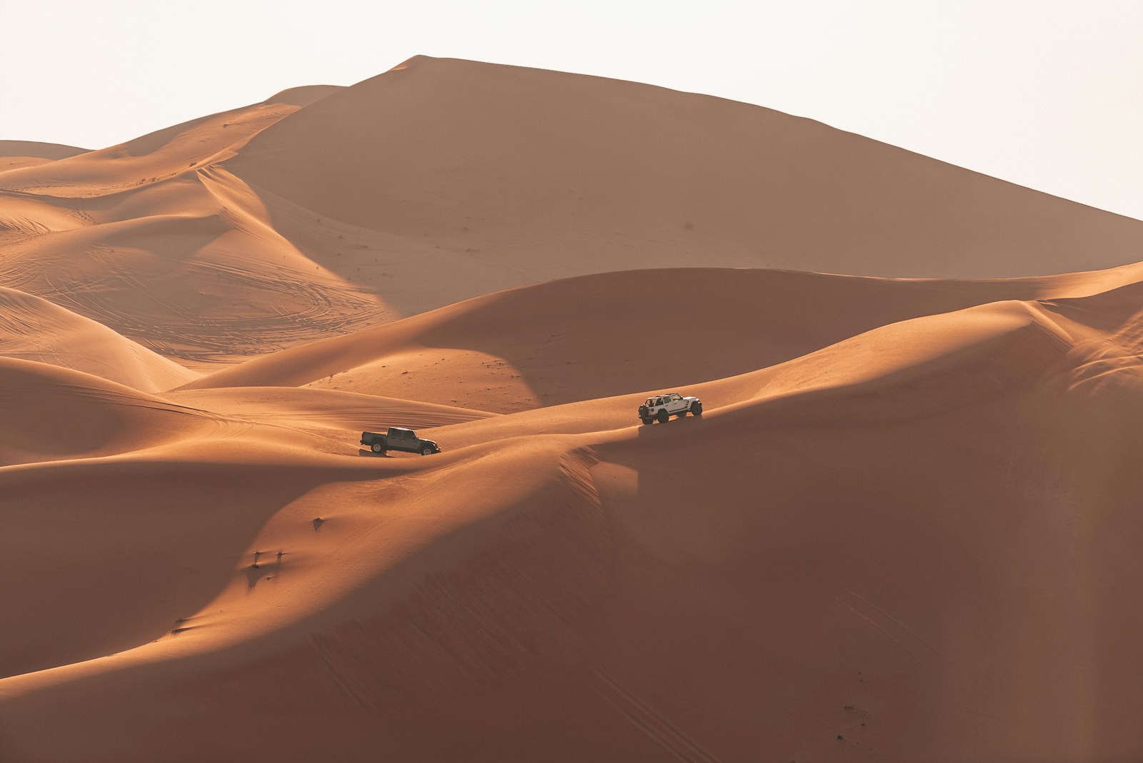 Off-road vehicles travelling across sweeping sand dunes near Dubai